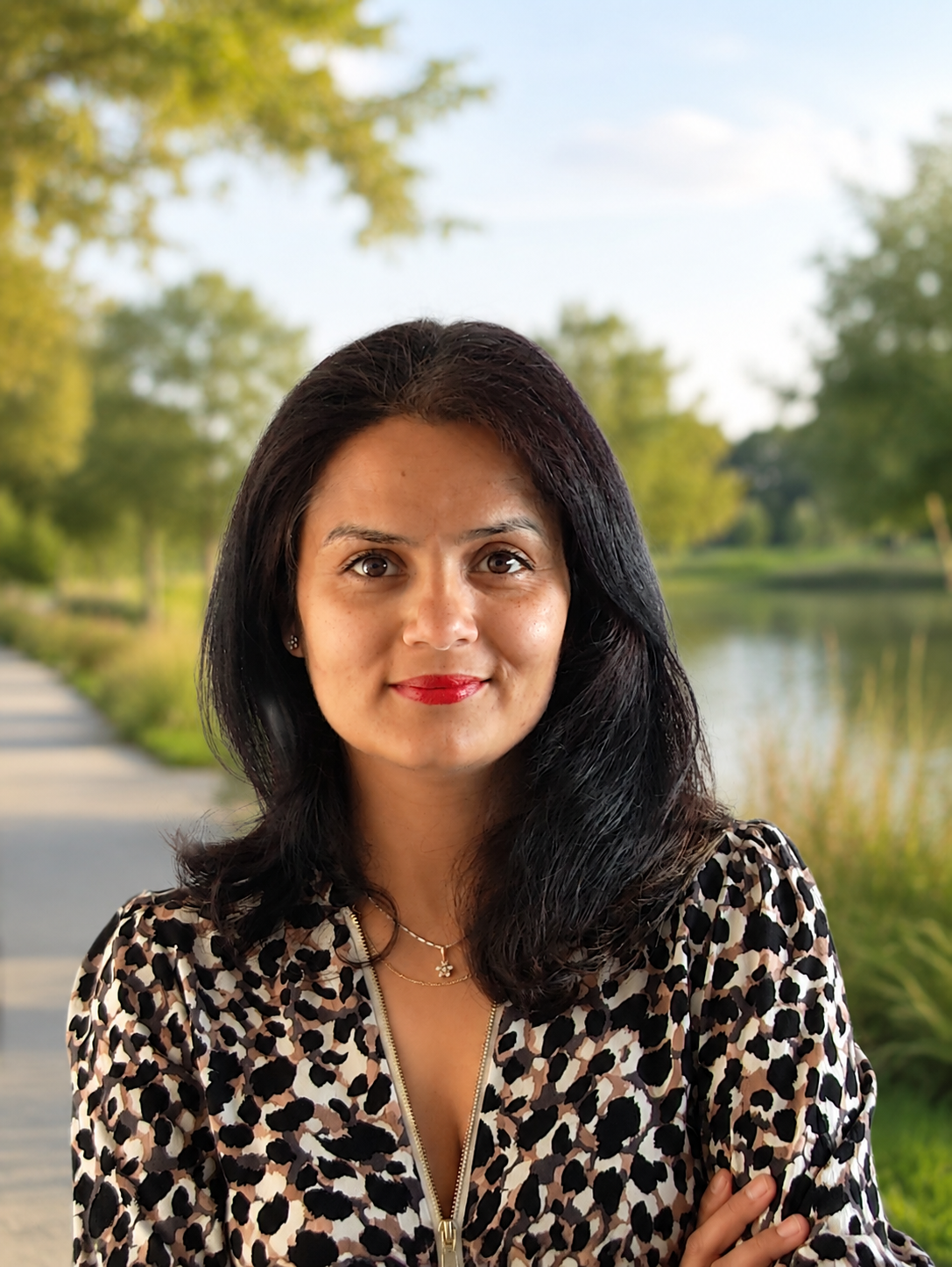 Neha Mehta, Chartered Accountant and financial coach, standing by a lake at golden hour
